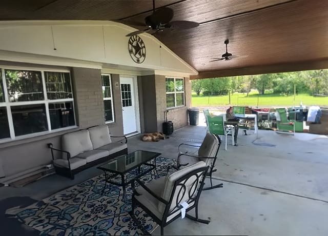 A patio with furniture and a table outside.