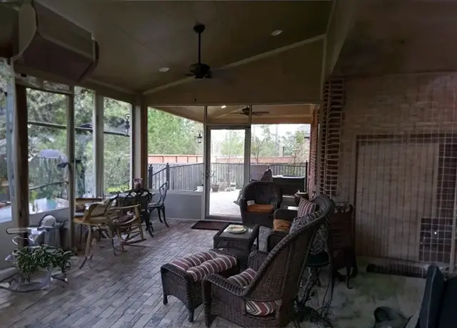 A man sitting on the back of a chair in front of a window.