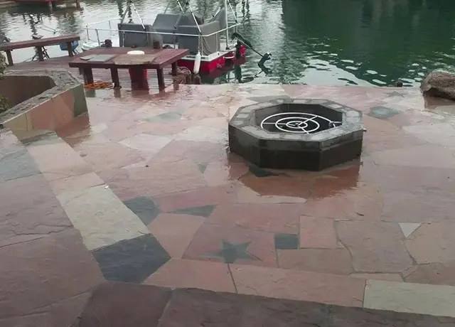 A fire pit sitting next to the water.