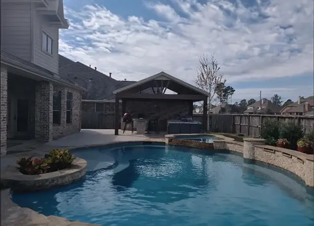 A pool with a hot tub in the middle of it.