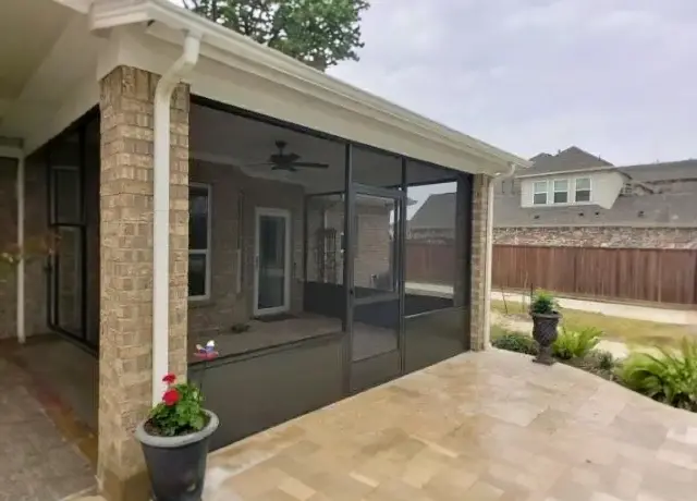 A patio with sliding glass doors and brick walls.