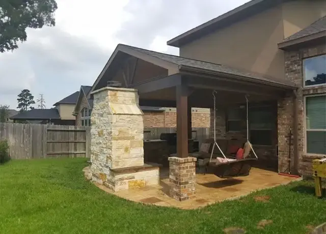 A patio with swings and a fire pit.