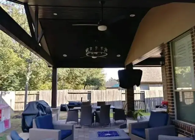 A patio with couches and tables under an awning.