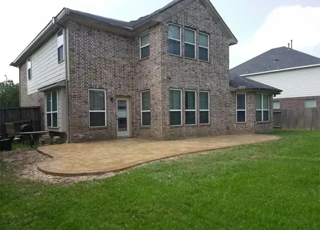 A large brick house with grass in the yard.