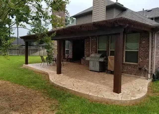 A patio with an awning and a grill on the side.