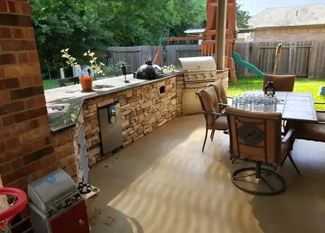 A patio with an outdoor kitchen and table