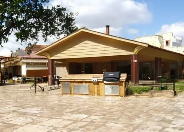 A large outdoor grill sitting outside of a house.