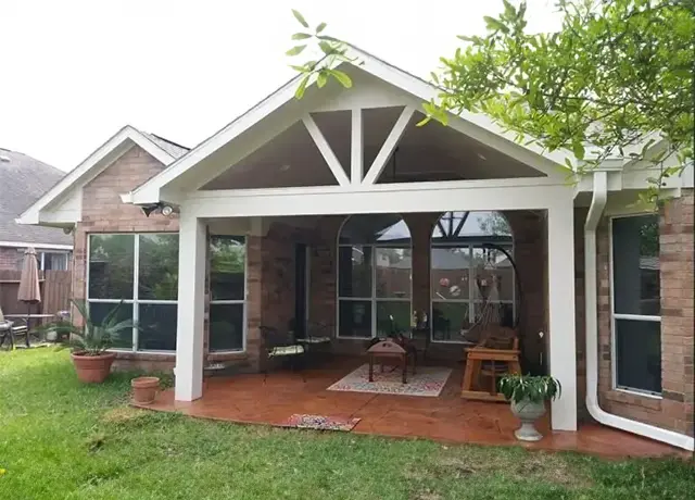 A patio with an open roof and brick flooring.