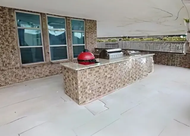 A large outdoor kitchen with a red helmet on top of it.