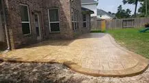 A brick patio with grass growing in the middle of it.