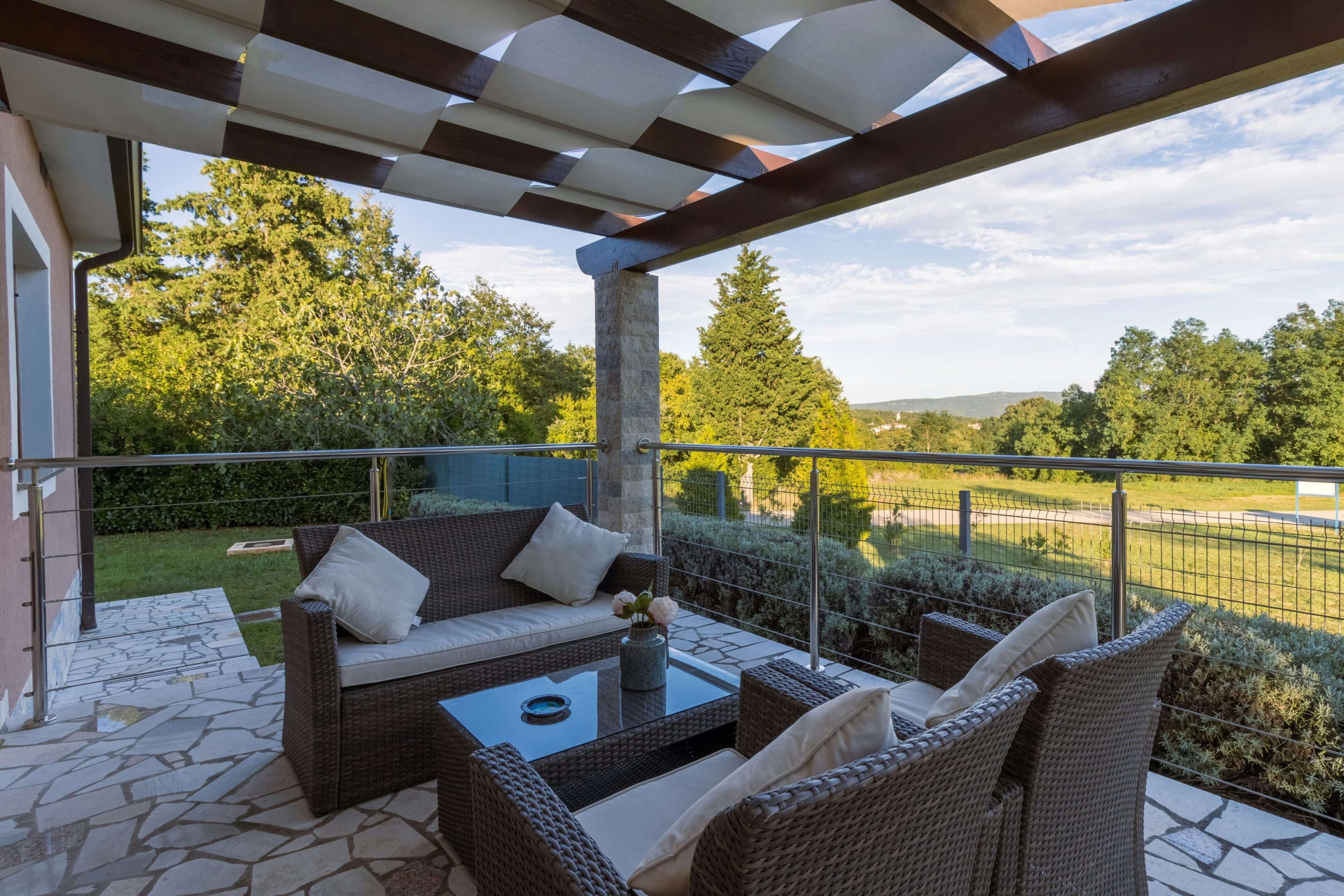 A patio with furniture and a pergola over the top of it.